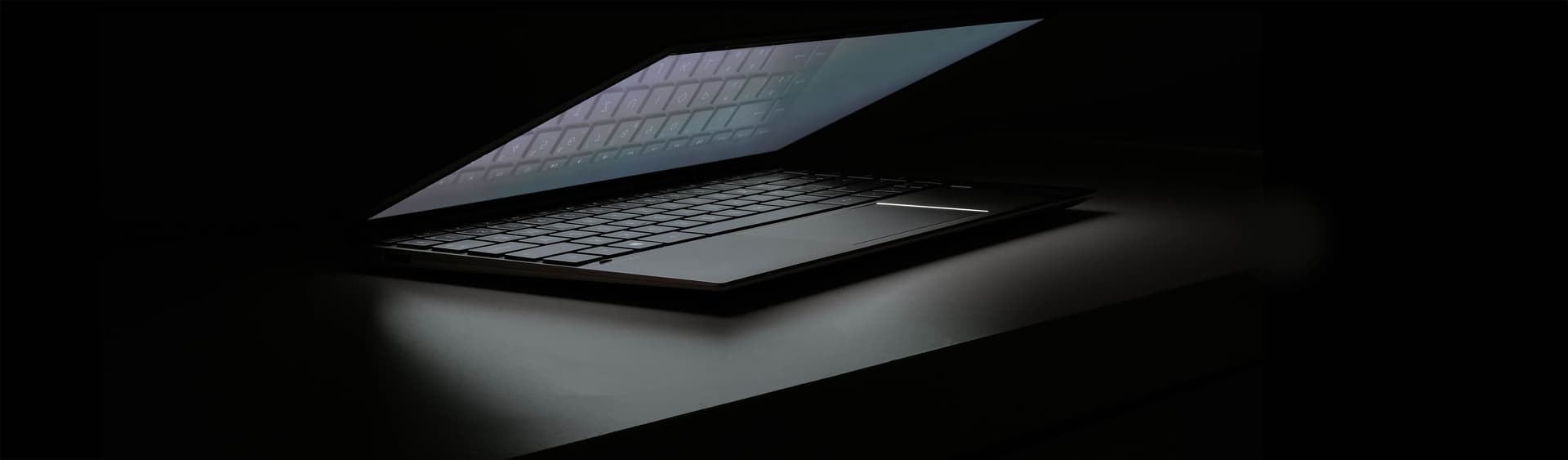 Backlit laptop screen glowing in a dark workshop